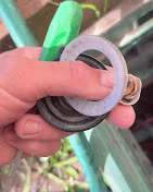 Hand holding replacement sprinkler washers and gaskets